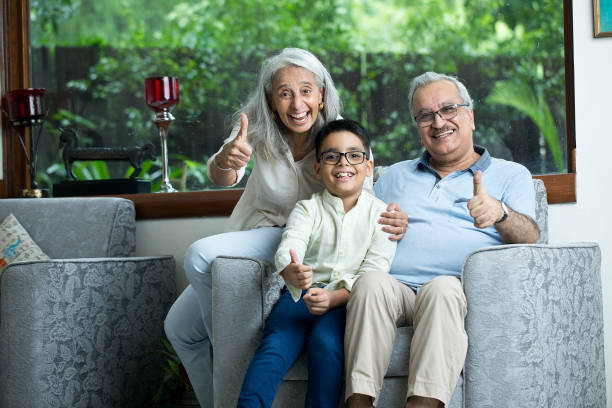 istock Happy Senior Couple With Grandson Showing Thumb Up 1419871221