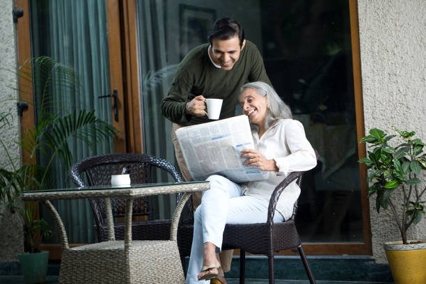 мужчина со старшей матерью дома - newspaper reading mother women стоковые фото и изображения