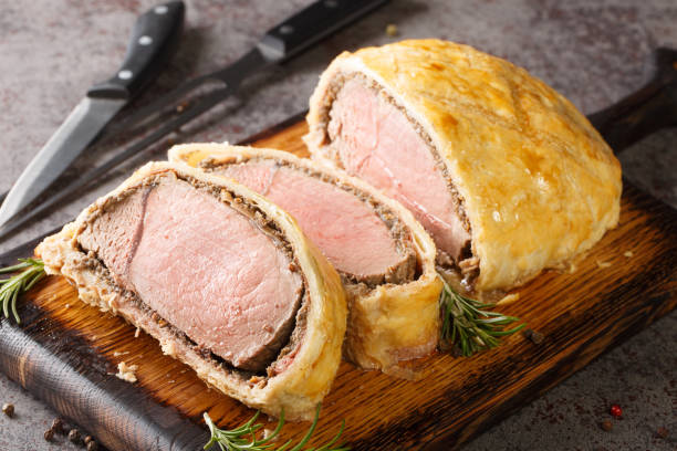 istock Medium Beef Wellington classic sliced steak closeup on wooden board. Horizontal 1419872335