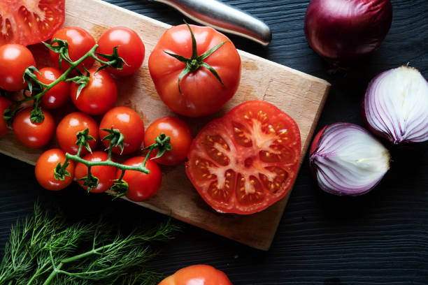 istock Flat lay composition of different tomatoes, red onion and dill on dark wooden background. 1419872475