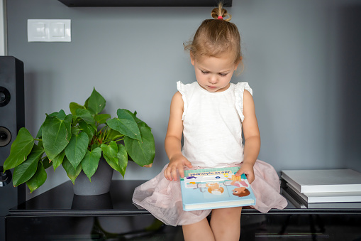 Adorable toddler little girl reading book at home. Happiness child reading book for preschool enjoy with learning education by yourself. Education concept. High quality photo