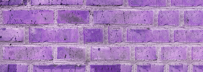 Banner background of an old brick wall, vintage brickwork texture, close-up, purple tinting.