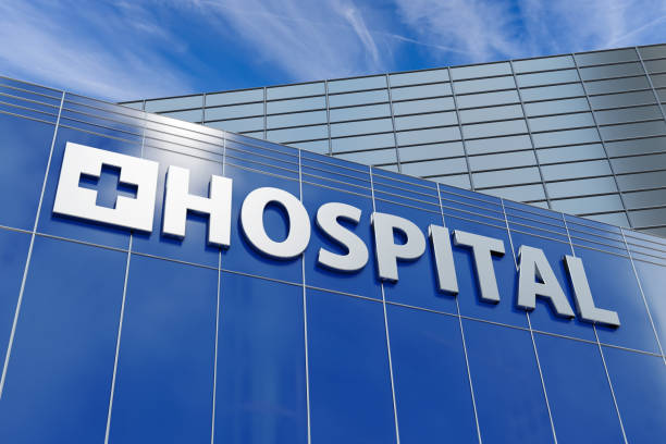 building facade of a hospital in commercial and business district under blue sky - hospital imagens e fotografias de stock