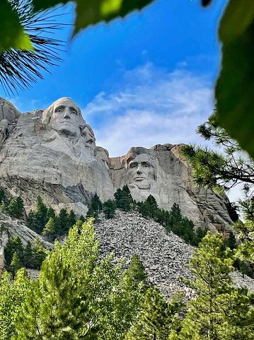 View of U.S. Presidents George Washington, Thomas Jefferson (partial view), Theodore Roosevelt (obscured), and Abraham Lincoln sculptures at Mount Rushmore National Monument.