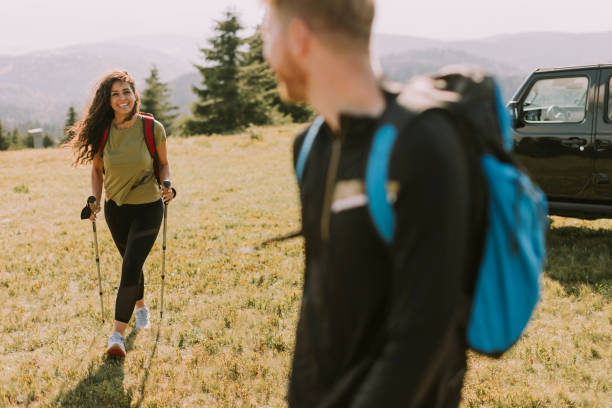 istock Smiling couple starting walking with backpacks over green hills 1419888041