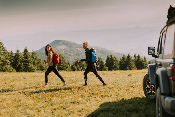 istock Smiling couple starting walking with backpacks over green hills 1419888097
