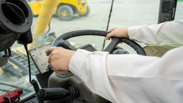 Female Foreman Drive a forklift container cargo forklift and use walkie talkie for communication during Driveing control forklift concept service and transportation logistic.