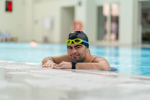 Professional male swimmer in action inside swimming pool. View underwater