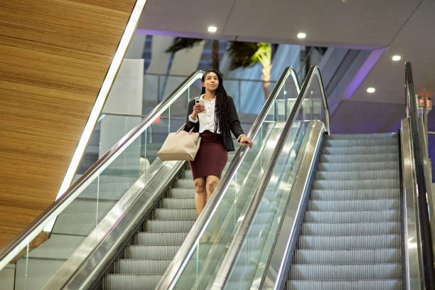 istock Black businesswoman riding escalator 1419892199
