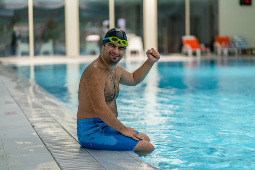 Latin American man recovering from an injury and doing hydrotherapy using some weights