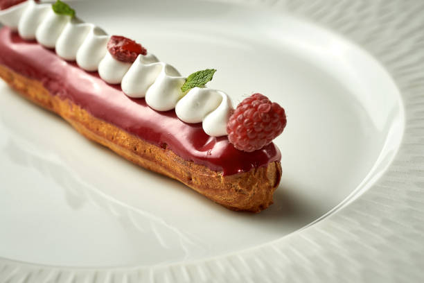 istock Eclair with berry glaze on a plate. Noise added in post-production. Selective focus 1419897284