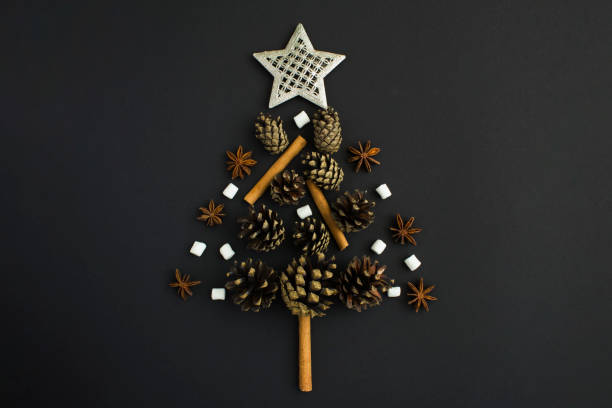 istock Christmas tree from pine cone, cinnamon, marshmallow and anise on the black background. Flat lay. Copy space. 1419900318