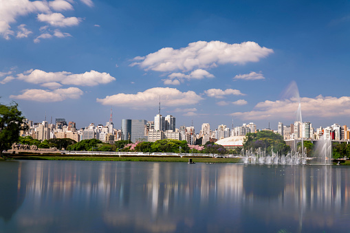 The lake in the Ibirapuera´s park  with the water source working and the city in the background