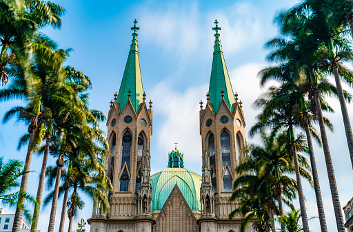 Facade of the cathedral  building and the palm trees of  located in the middle of Sao Paulo in a sunny day