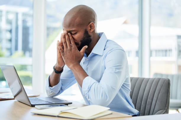 stress, ansia e preoccupazione con un uomo d'affari che soffre di mal di testa, emicrania o stanchezza mentale e burnout. giovane maschio che lavora nel suo ufficio, sentendo la pressione di una scadenza e lottando - fare fatica foto e immagini stock