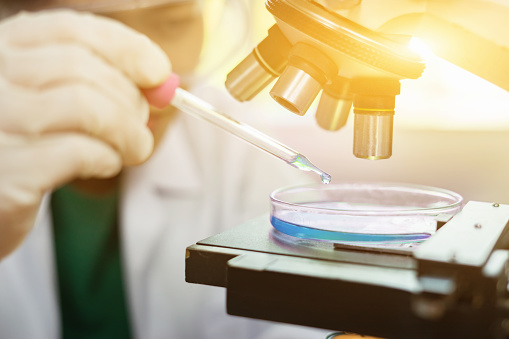 Shot of a young woman using a machine to conduct a medical test in a laboratory