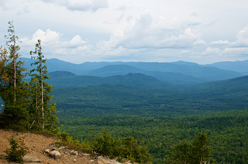 Spectacular scenic landscape view of the Adirondack mountains from the top of Cobble Lookout in Wilmington, New York on a summer afternoon. Esther, Whiteface, and Giant Mountains can be seen in distance.