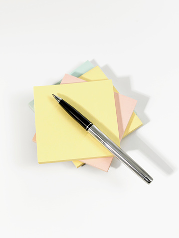 Stack of Adhesive notes and a chic pen on white background