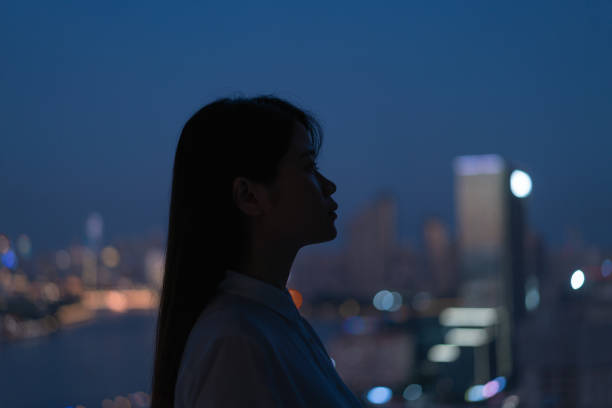 istock woman stands by the window at night 1419918082