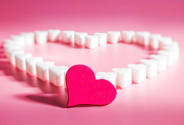 istock Heart made of sugar cube hearts on pink background, selective focus 1419918883