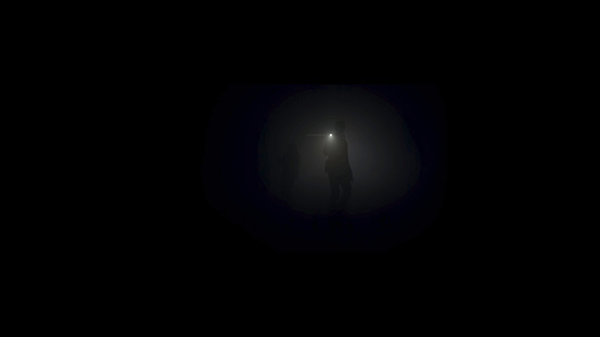 A lonely man exploring deep dark cave. Silhouette of a person standing inside of the cave on the background of the mystical moonlit.