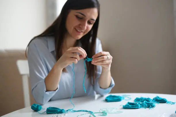 Photo of Woman embroiders beads and makes brushes, handwork