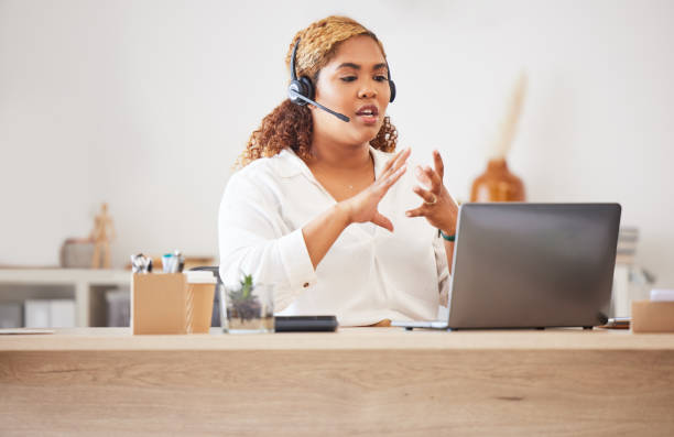 istock Female call center agent talking on headset while doing a video or zoom call and working in an office. Businesswoman consulting and explaining while on a call for customer sales and service support 1419921240