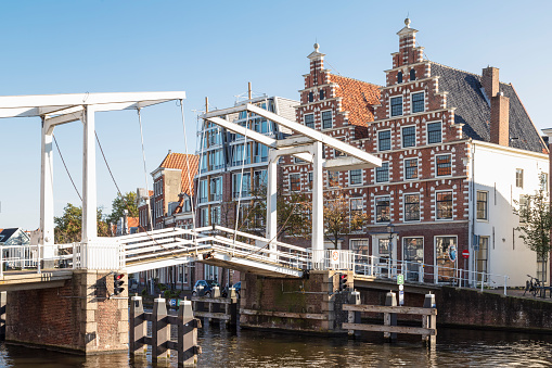 Amsterdam, Netherlands - July 8, 2015: A person on a bicycle crossing a drawbridge over one of the canals of the city.