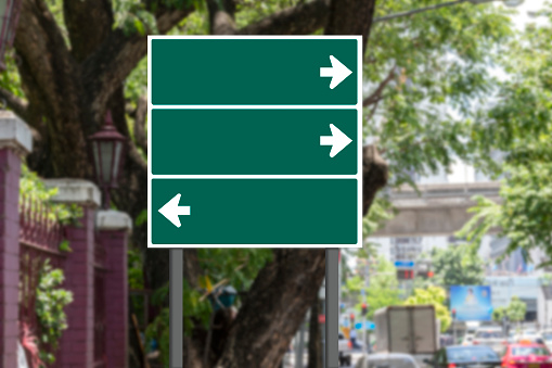 Mockup green road sign with white arrow on footpath