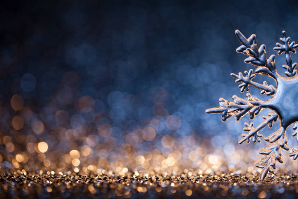 Huge ice crystal on defocused gold and blue lights - Christmas Ornament Decoration Bokeh Background stock photo