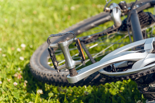 detail of a bicycle pedal with a blurry green background