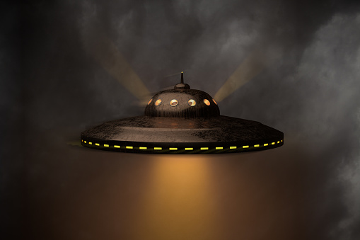 An unidentified flying object (UFO) against a moody sky. Lightrays visible. Slight motion unsharpness (halo). 3d render