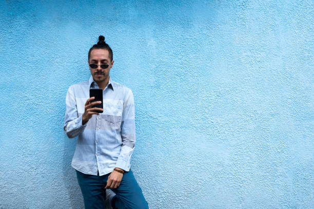 istock Young man is using his mobile in the street while making a video call 1419930699