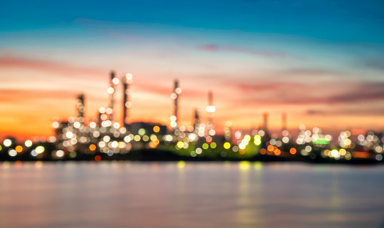 Bokeh image of Oil and gas Refinery factory with beautiful sky at sunrise.
