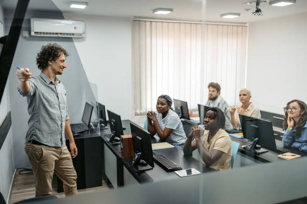 jovem professor do sexo masculino ensinando uma aula de programação - computer lab computer people computer monitor - fotografias e filmes do acervo