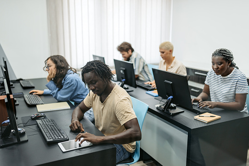 Multiracial group of students sitting in a programing class and learning