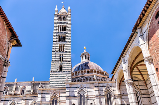 Sienna, Italy - July 14, 2022: The bell tower and Duomo di siena in Siena Italy
