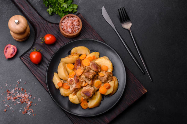 istock Beef meat and vegetables stew on a black plate with roasted potatoes 1419944442