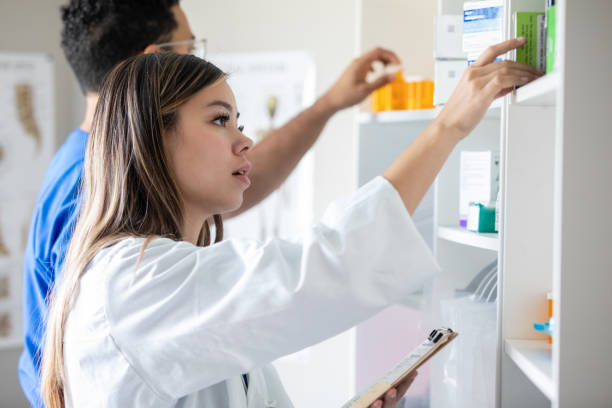 Pharmacist or pharmacy technicians sorting medication and fulfilling orders in busy retail pharmacy stock photo