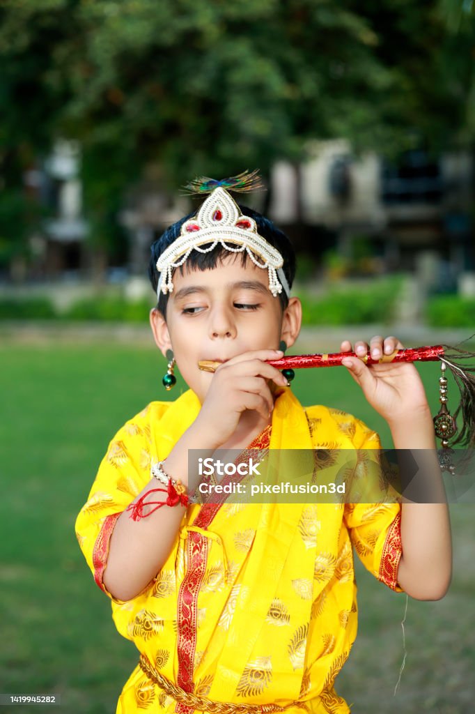 Little krishna portrait with flute outdoor in park Little krishna of Indian ethnicity during Janmashtami festival portrait with flute outdoor in park. Child Stock Photo