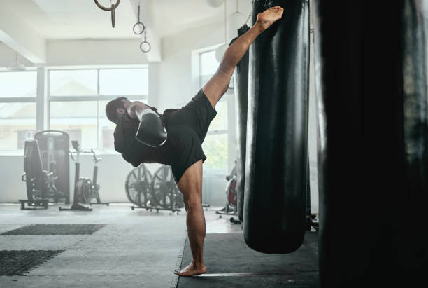 istock Professional, fit and active male fighter training with a punching bag in a gym. kickboxer practicing, training and fitness exercise for competitive fight, tournament or competition in a health club 1419945960
