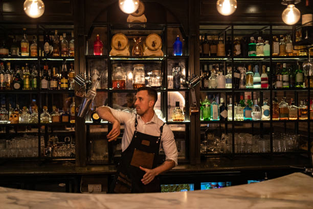 istock Handsome bartender uses shaker to make cocktail at bar counter 1419947949