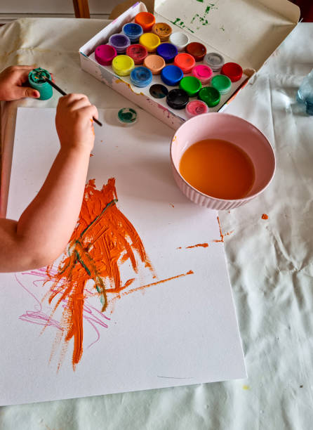 istock Toddler draws creatively with finger paint 1419950962
