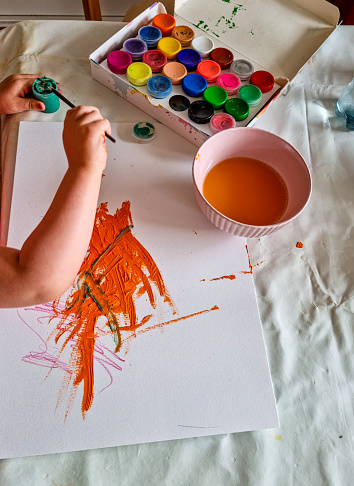 Toddler draws creatively with finger paint