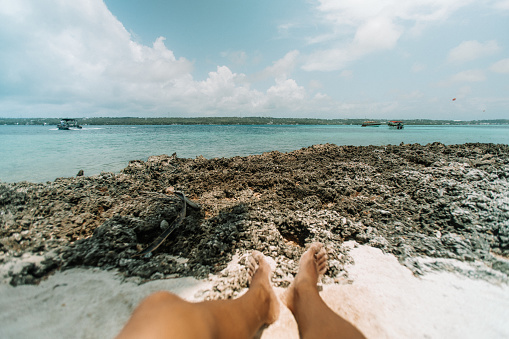 First person view of the sea. part of the man's legs appear in the foreground of the image. The sea and yours are spectacular.