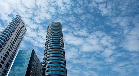 Modern tower buildings or skyscrapers in financial district with cloud on sunny day. bottom view