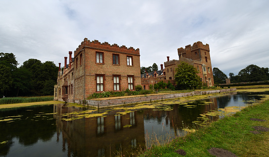 Oxborough, Norfolk, England - July 12, 2022: Oxburgh Hall with moat and reflections