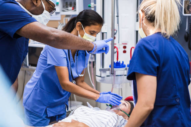 istock Male doctor evaluates female patient as nurses administer oxygen 1419962969
