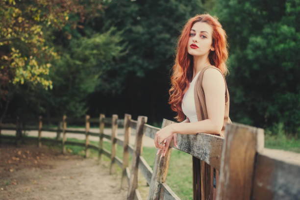 Cowgirl leaning on a fence