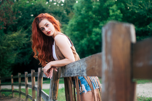 Cowgirl leaning on a fence